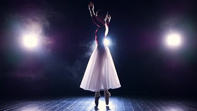 芭蕾舞演员在黑暗中平衡并转身。