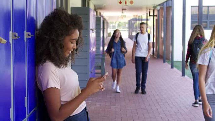 女孩使用电话和男孩使用储物柜在学校走廊