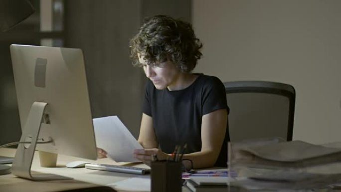 女人检查文件并在计算机上工作
