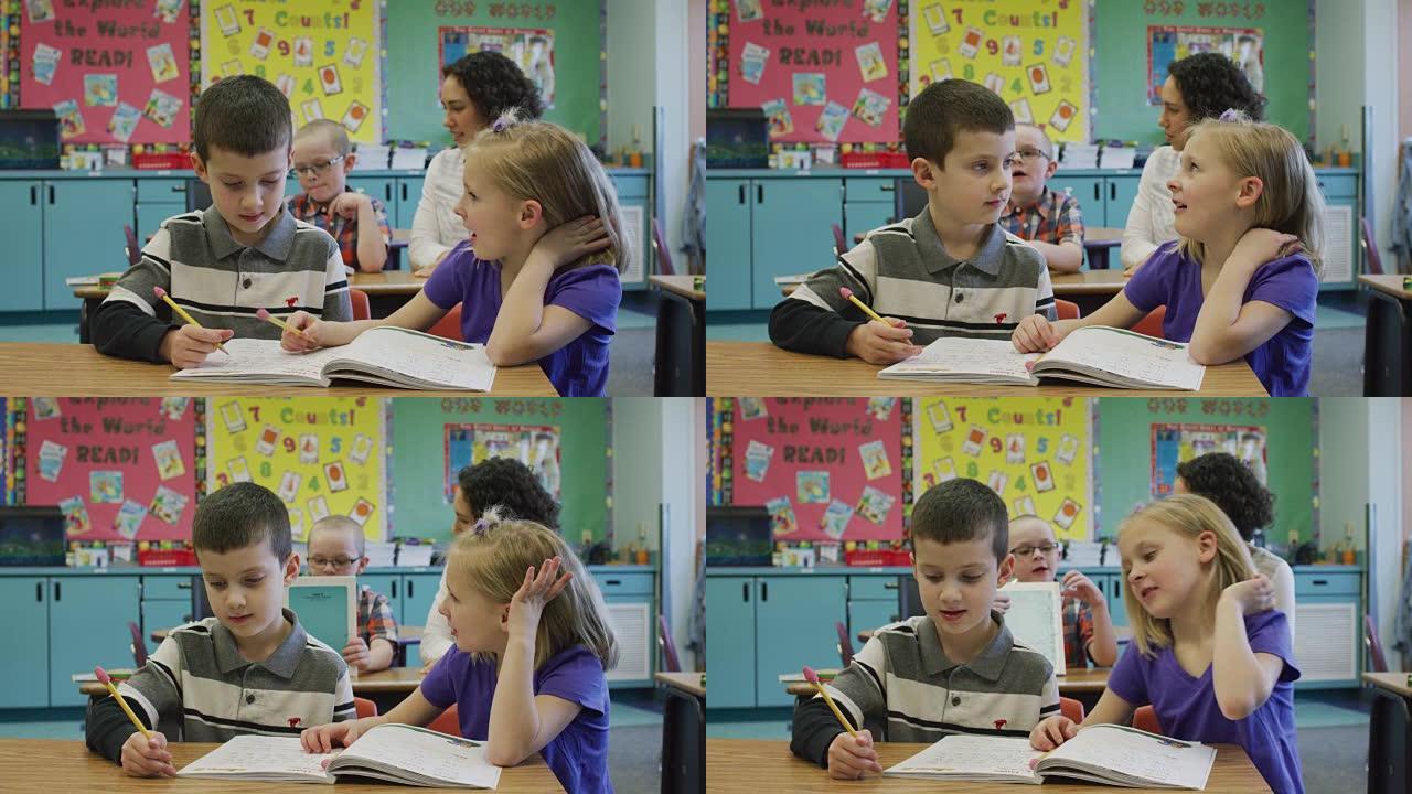 年轻的男孩和女孩在他们的小学教室里共用一张桌子