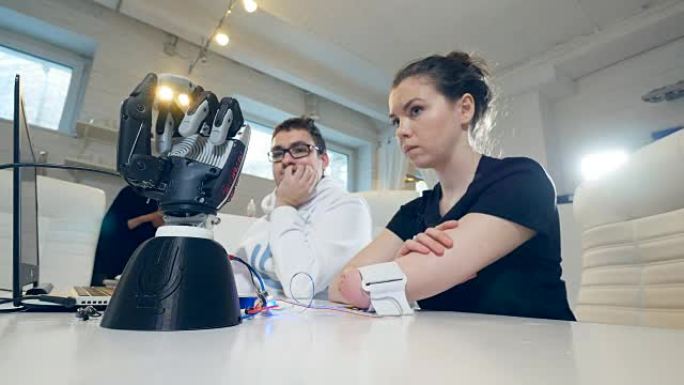 在实验室中，机器人的手随着残疾女孩手臂的运动而移动。