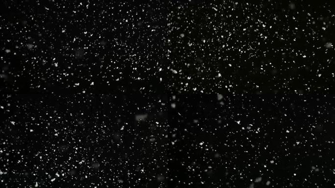 暴风雨天气，降雪，黑色背景上孤立的中等大小的雪花。易于在混合/叠加模式下使用的真实镜头光斑。