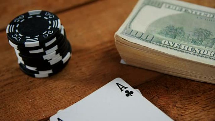 扑克桌4k上扑克牌、美元和赌场筹码的特写
