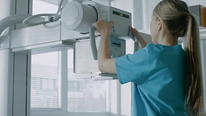 在医院，女技术员调整x射线扫描仪/机器。拥有技术先进的医疗设备和专业人才的现代化医院。