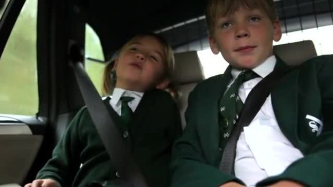 两个穿着制服的孩子被开车上学