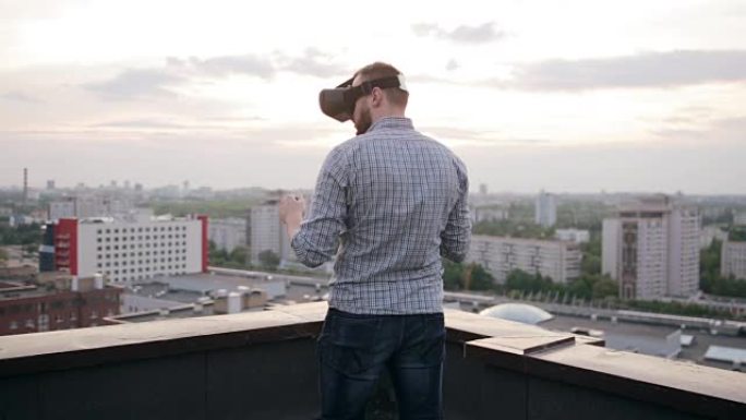 男子在屋顶上使用虚拟现实眼镜