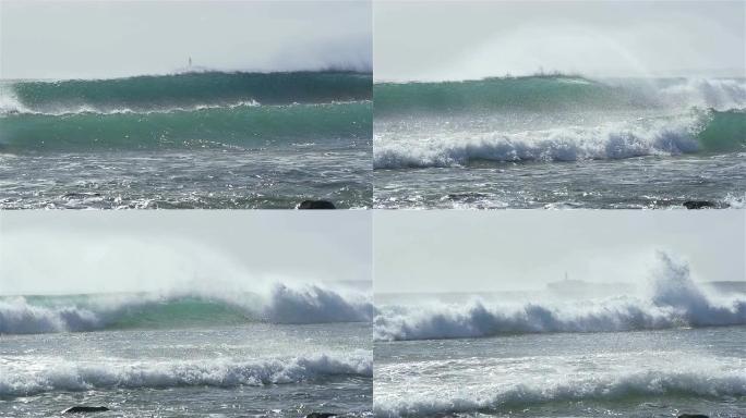 慢动作: 巨大的海浪冲破并向海滩飞溅