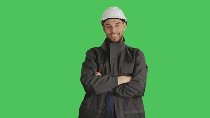 一名工人戴着安全帽，双臂交叉在胸前。背景是绿色屏幕。