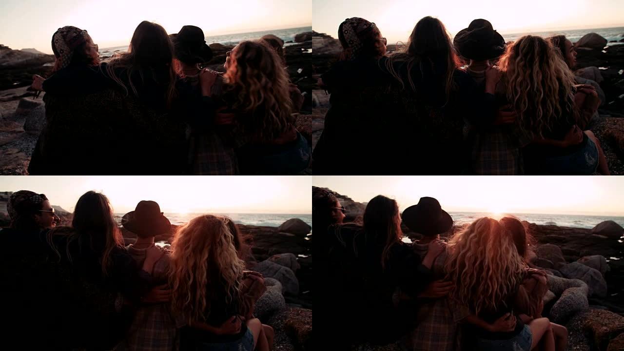 年轻的成年朋友在海上日落时拥抱