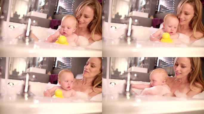 现代妈妈和婴儿女儿一起泡泡浴