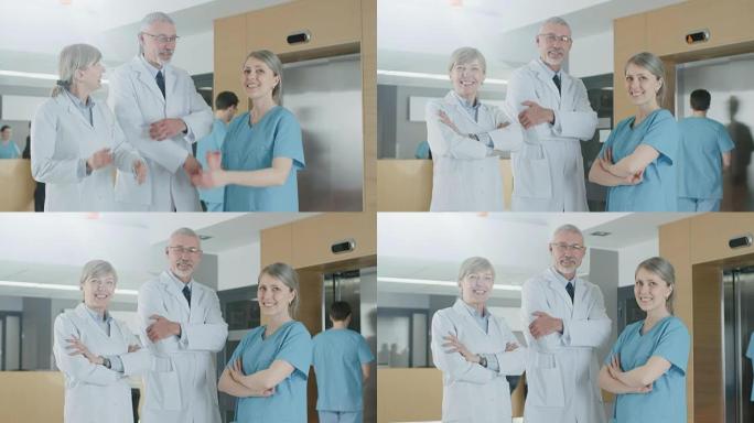 两名医生和一名护士在医院大楼里摆姿势的肖像，双臂交叉微笑。拯救生命的医疗专业人士中的杰出人士。