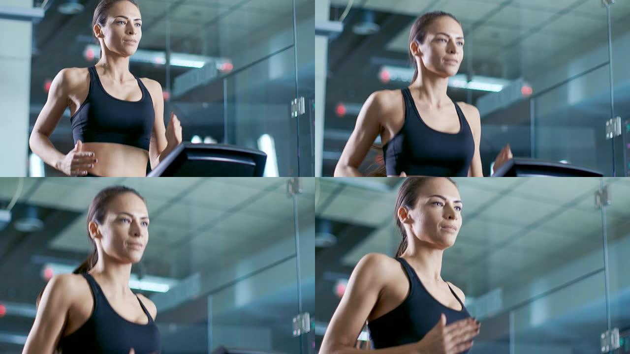 在科学运动实验室中，美女运动员在跑步机上行走，电极附着在她的身体上，监视器显示EKG数据。慢动作。低