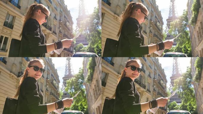 巴黎的游客阅读地图，站在一条小巷里，可以看到埃菲尔铁塔
