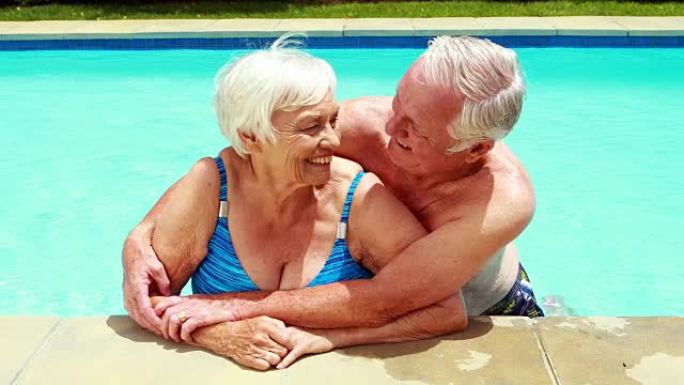 高级夫妇在游泳池中互相拥抱的肖像