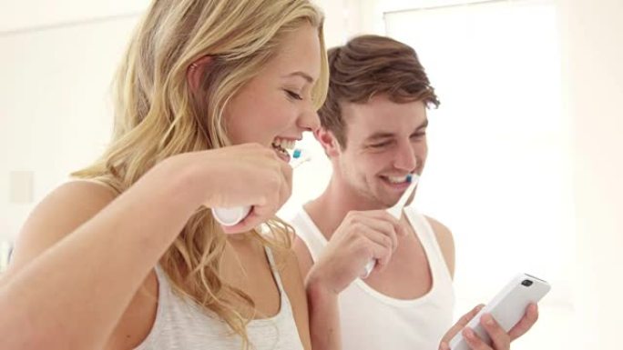 幸福的夫妻刷牙并使用电话