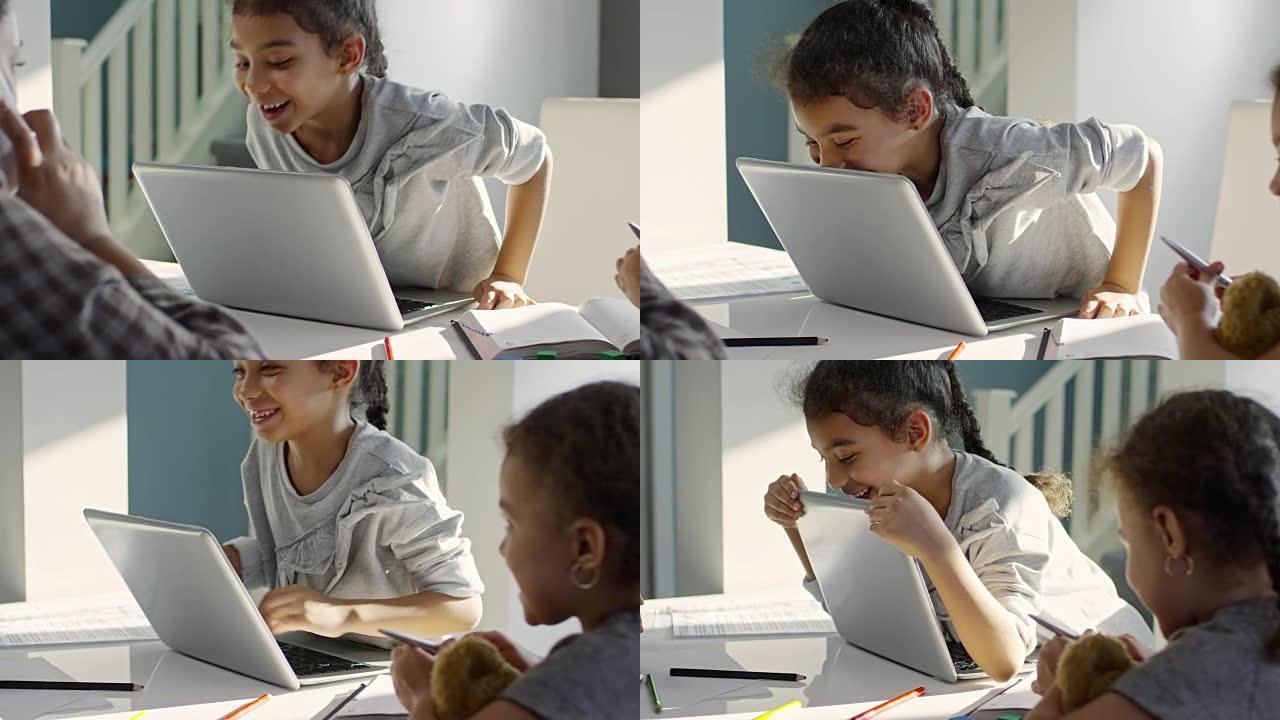 笑着看笔记本电脑后面的小女孩