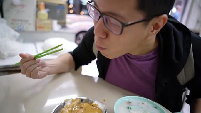 在香港吃传统酱汁米粉卷的人。