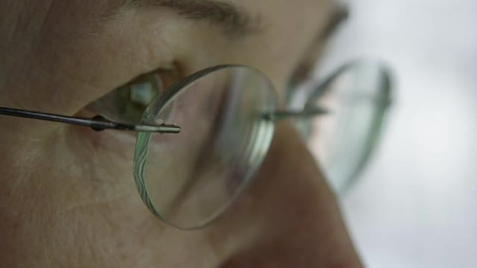 宏观: 戴着眼镜的女性的眼睛在计算机显示器上反射图形