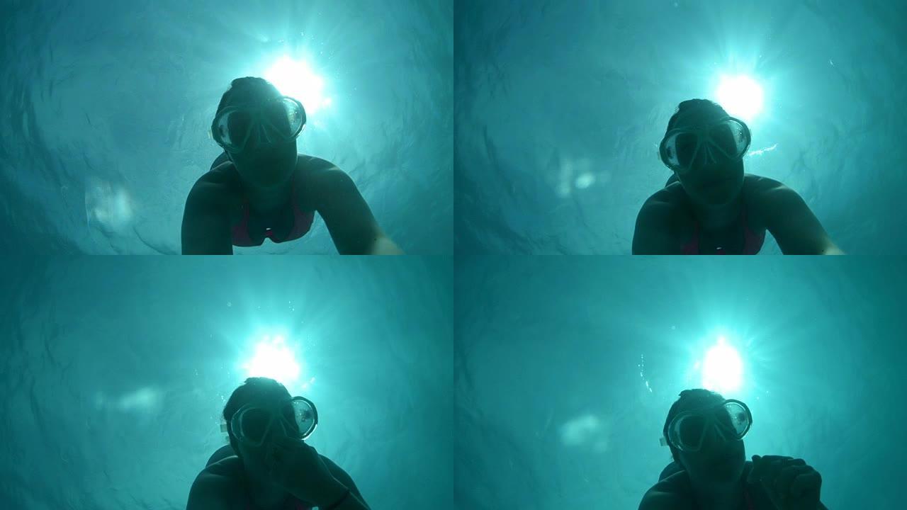 水下自拍照: 年轻女子在翡翠海洋潜水时调节压力