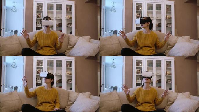 美丽的年轻女子坐在客厅的沙发上，使用VR耳机。4K