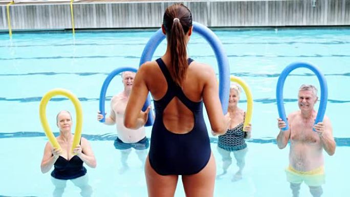 游泳教练协助老年人进行锻炼