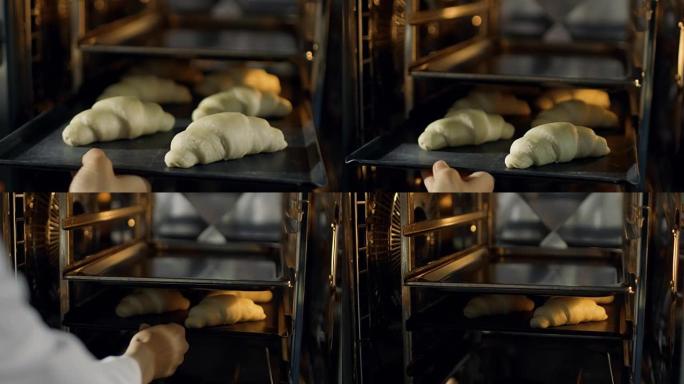 专业面包师将羊角面包放入烤箱。