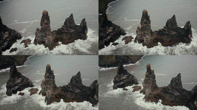 冰岛的山魔脚趾鸟瞰海鸥巢。直升机在黑海滩上的悬崖上飞来飞去