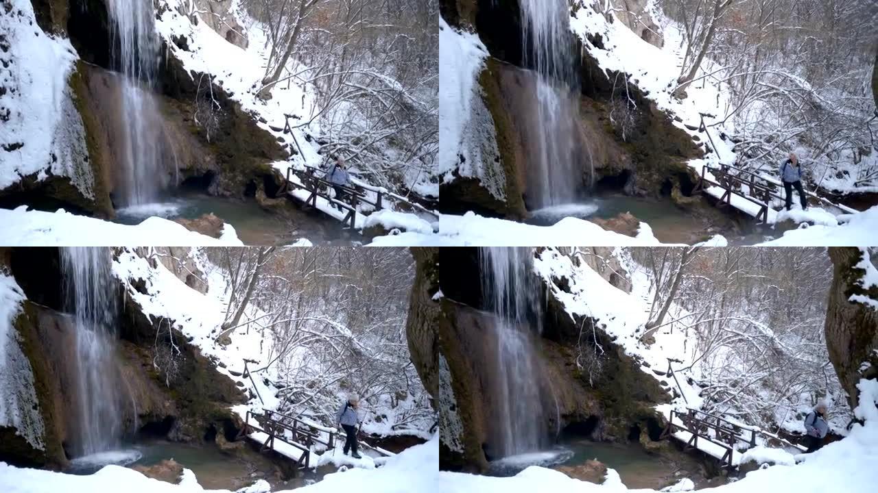 Beautiful female hiker walking near the waterfall