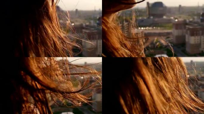 风吹起长长的黑发。女孩低着头站在屋顶上。特写。慢动作