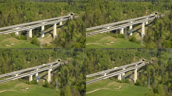 空中: 汽车和半卡车在大型高速公路高架桥上行驶并进入隧道