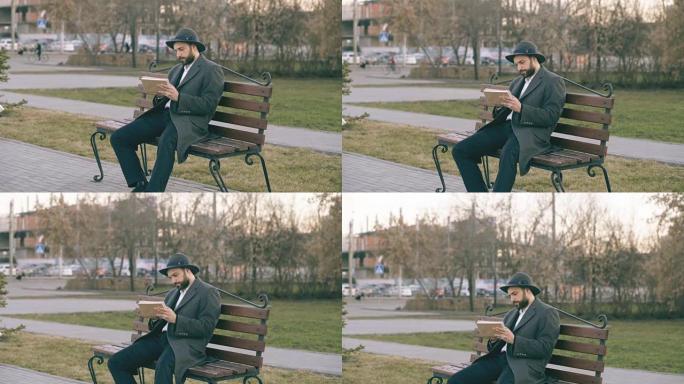 Hipser创意艺术家男人戴着帽子和外套，用钢笔和素描本坐在公园的城市街道长椅上