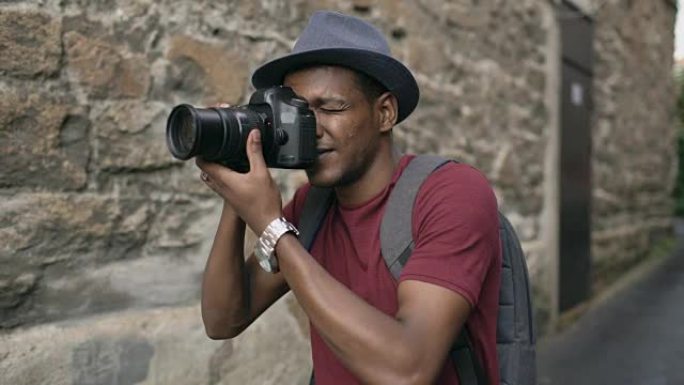 非洲快乐游客在他的单反相机上拍照。年轻人在欧洲旅行