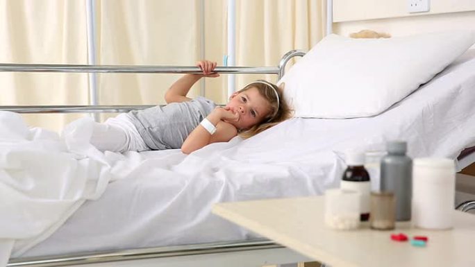 躺在病床上看药的小女孩