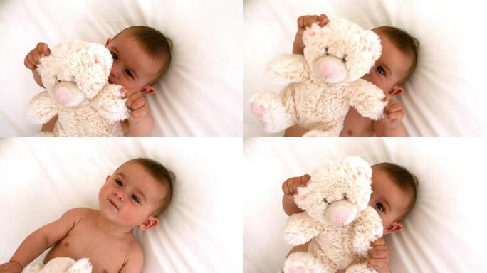 可爱的婴儿和泰迪熊在床上