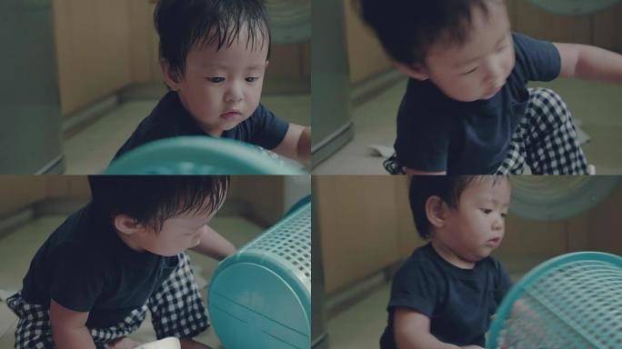 亚洲男婴学习在家折叠衣物