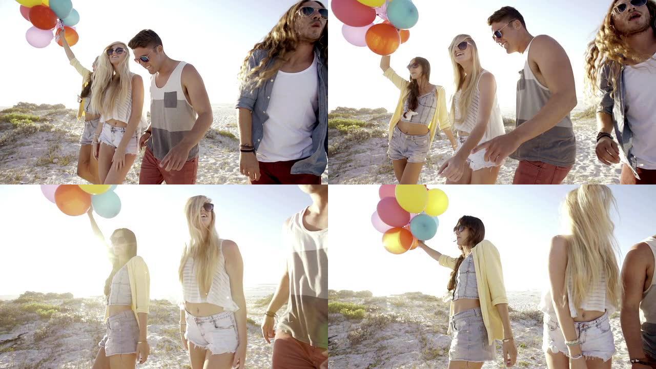 朋友在海滩上与气球跳舞