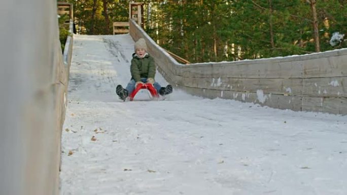 快乐男孩在冬天滑雪橇