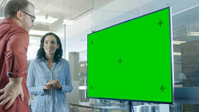 深夜，会议室里的男女讨论了模拟色度键绿屏电视。