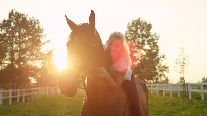 慢镜头:一个漂亮的金发女孩坐在一匹棕色的马背上
