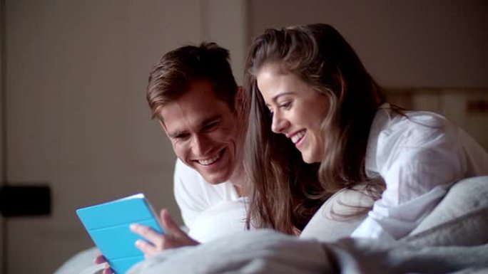 夫妇在床上共享数字平板电脑