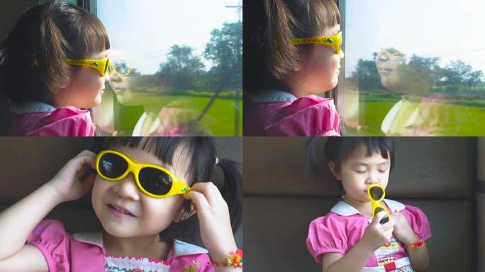 小女孩坐火车在窗外看。