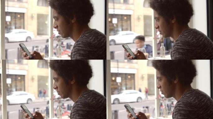 年轻人在咖啡馆使用手机更新社交媒体