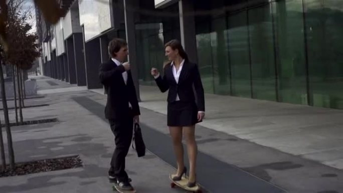 年轻的商业夫妇在滑板时拳头碰撞