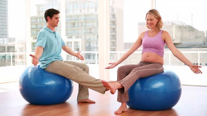 孕妇与私人教练一起做瑜伽