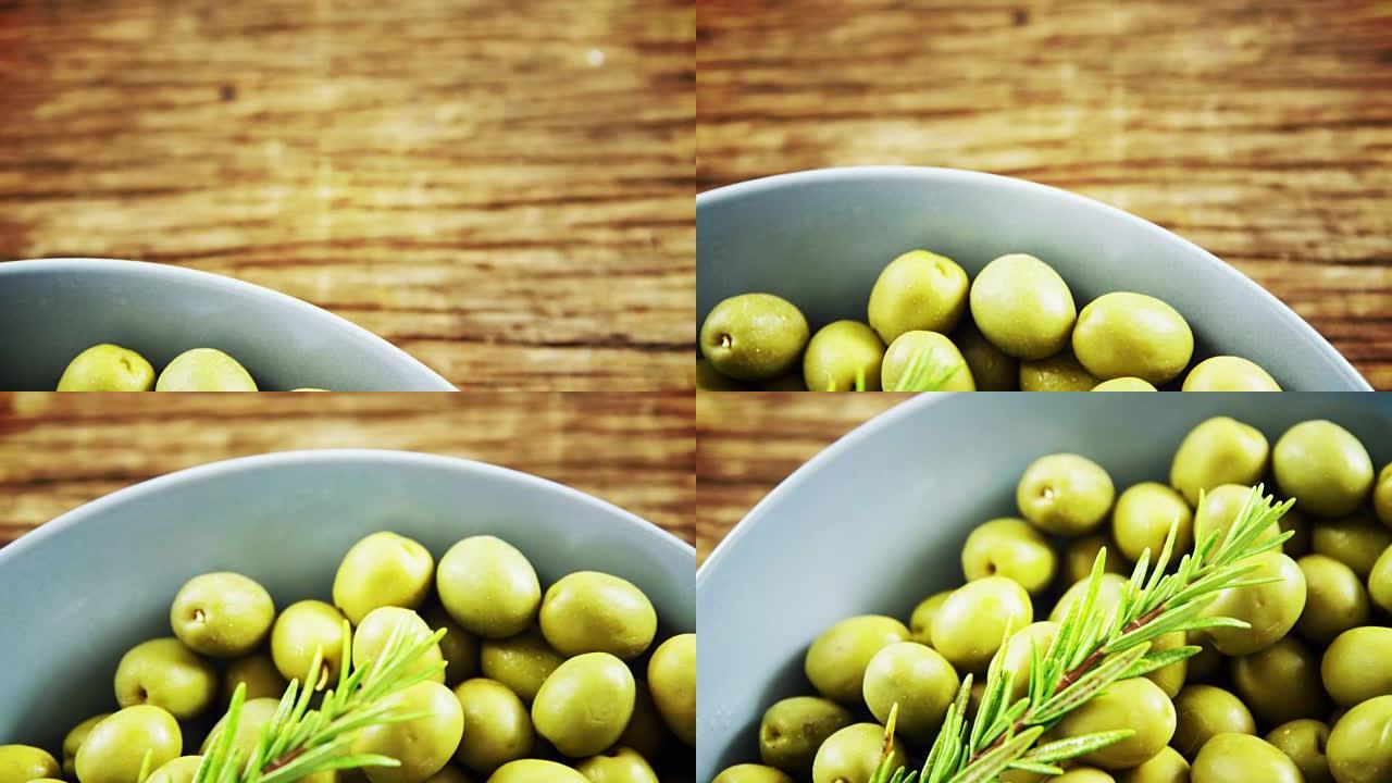 碗中的新鲜绿橄榄和迷迭香