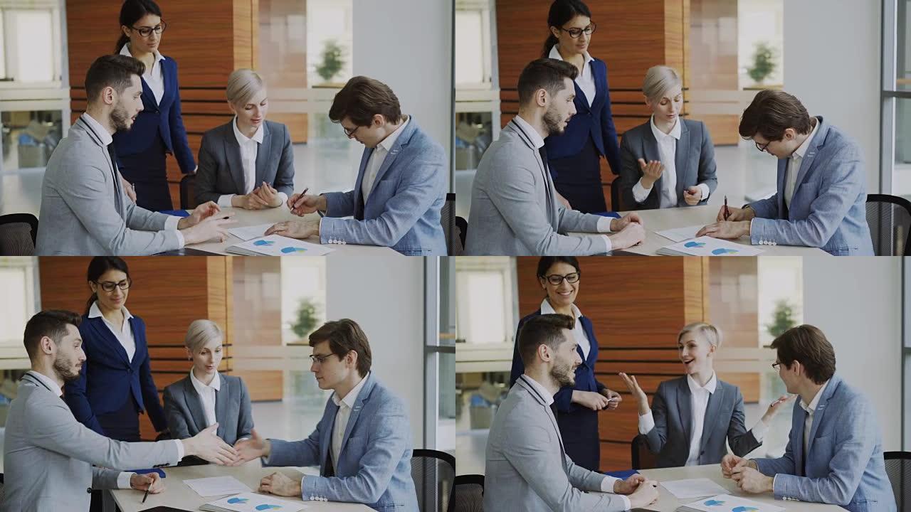 穿着西装的年轻商人与同事签订合同并握手，而公司律师坐在现代的办公室里解释合伙关系的细节