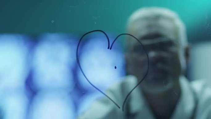 科学家正在用玻璃上的标记画心脏。在4k (UHD) 的红色电影相机上拍摄。