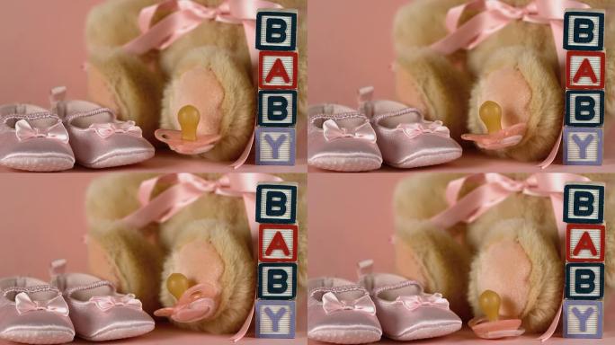 粉红色的安抚用品落在婴儿鞋和泰迪熊旁边