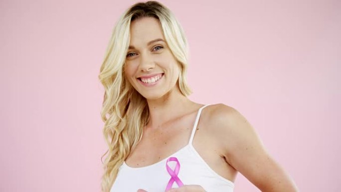 微笑的女人展示乳腺癌意识丝带