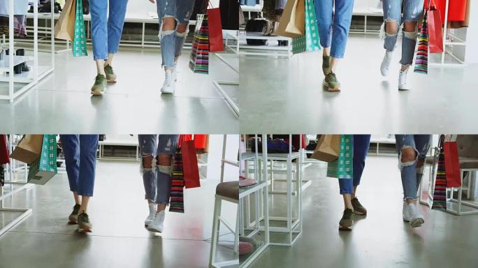 特写镜头多莉拍摄的女性双腿在豪华商店中缓慢行走。妇女穿着牛仔裤和运动鞋，背着明亮的纸袋。